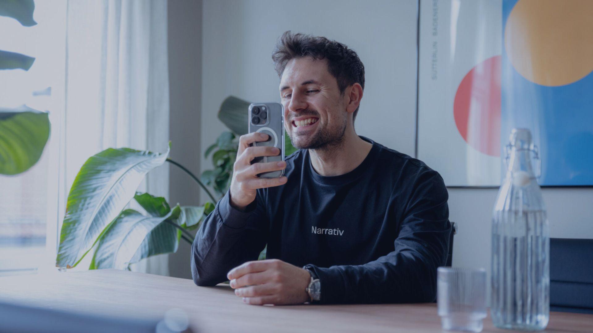 mann sjekker tennene på mobilen