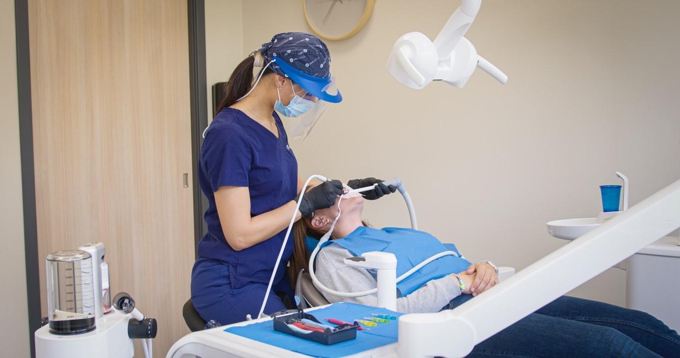 Tannpleier ved Oris Dental utfører tannrens på en pasient i tannlegestolen på tannklinikk.