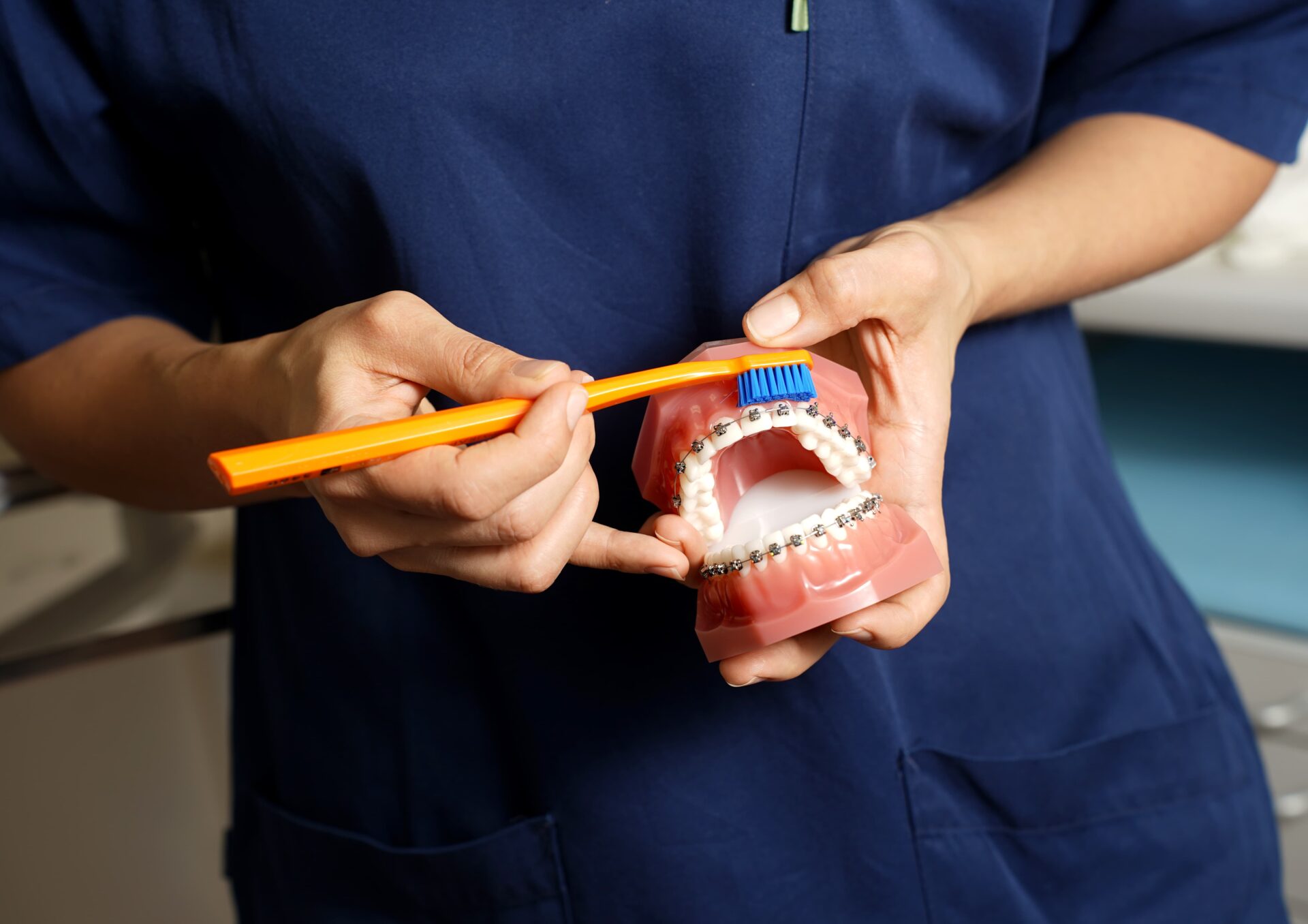 bilde av tannlege som demonstrerer riktig tannpuss for reulering