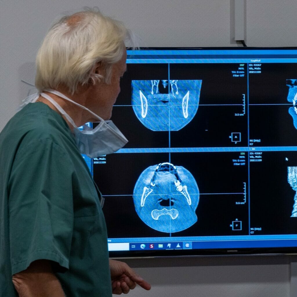 Dagfinn Nilsen er oralkirurg ved Oris Dental i Oslo. og viser frem røtgenbilder på en monitor for å illustrere hvordan man kan avdekke kreft i munnhulen.