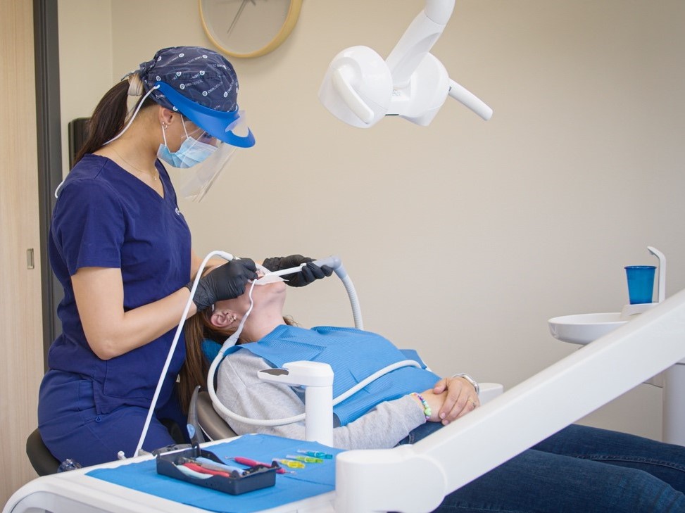 Tannpleier ved Oris Dental utfører tannrens på en pasient i tannlegestolen på tannklinikk.